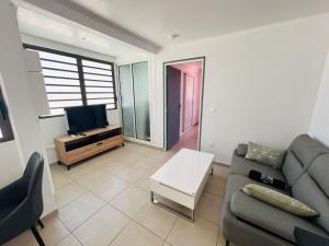 Appartement SOLEIL في كايان: غرفة معيشة مع أريكة وتلفزيون