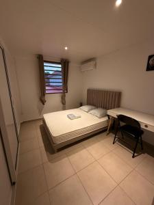 Appartement SOLEIL في كايان: غرفة نوم صغيرة بها سرير ومكتب