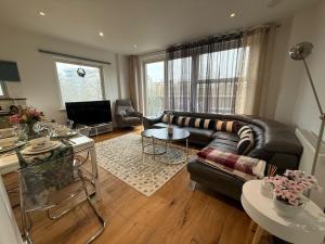a living room with a couch and a table at Balcony Breeze Modern 2-Bedroom in Colindale