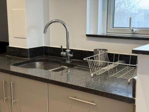 a kitchen counter with a sink and a window at Balcony Breeze Modern 2-Bedroom in Colindale +59 photos