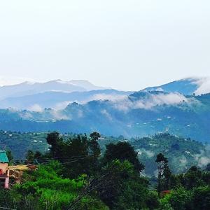 a view of a valley with mountains in the distance at Moonlight Camp Dhanachuli Mukteshwar in Nainital