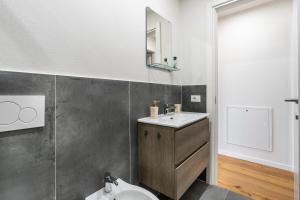 a bathroom with a sink and a toilet and a mirror at Scandicci Elite Home - Casa Moderna con Cortile e Parcheggio Gratuito in Scandicci +42 photos