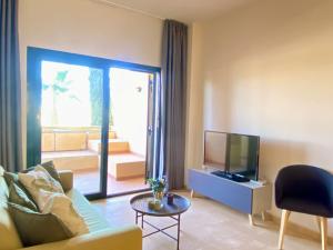 a living room with a couch and a television at Oasis Slow Life H44 by Gloove in Fuente Alamo