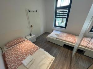 ein Schlafzimmer mit zwei Betten und einem Fenster in der Unterkunft Lebendige Stadtwohnung in Stadtnähe in Bremerhaven