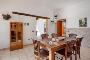 a dining room with a wooden table and chairs at Casa La Caldereta in Guatiza