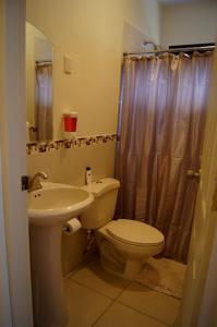 La salle de bains est pourvue de toilettes et d'un lavabo. dans l'établissement La Residencia Inn, à Jinotepe
