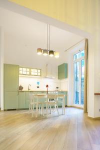 a kitchen with green cabinets and a table and chairs at Lucy's Flowers in La Spezia