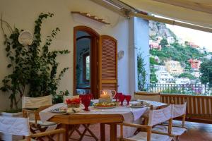 una sala da pranzo con tavolo, sedie e una finestra di Villa D'apuzzo nel cuore di Positano a Positano