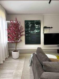 a living room with a couch and a potted plant at 6th Of October Signature Stay in 6th Of October