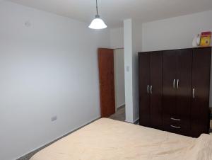 een slaapkamer met een bed en een houten kast bij dale dpto in Chilecito