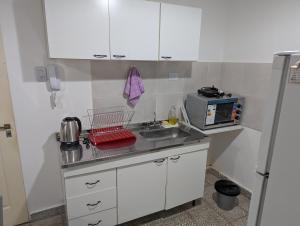 een kleine keuken met een spoelbak en een magnetron bij dale dpto in Chilecito +2 foto's