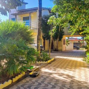 a driveway in front of a house with trees at Via sol casas temporada in Rio das Ostras