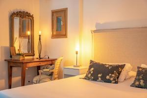 a bedroom with a bed and a desk and a mirror at I Carbonni - Bergerie 80m2 entre mer et montagne in Sotta