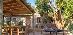 a patio with chairs and tables and a house at I Carbonni - Bergerie 80m2 entre mer et montagne in Sotta
