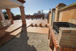 a patio with potted plants and a brick building at Casa Ana Mari in Conil de la Frontera