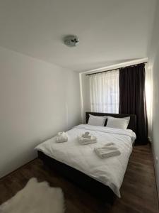 a bedroom with a bed with two towels on it at Apartament Dor de Munte Cavnic in Cavnic