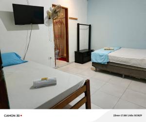 a room with two beds and a flat screen tv at Alojamiento LETICIA in Leticia