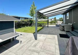 a patio with a bench and a picnic table at Chalet am See in Lathum