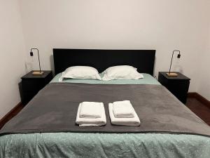 a bedroom with a bed with two nightstands with towels on it at Azul 31 in Lajes das Flores