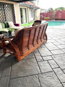 un banco de madera sentado en un patio junto a una piscina en MorningMist Boutique Sun, en Centurion 13 fotos más