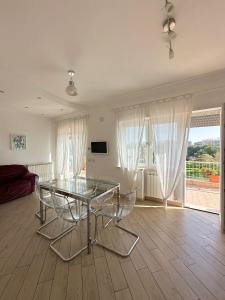 un soggiorno con tavolo e sedie in vetro di Terrazza sul Parco a Roma Altre 48 foto