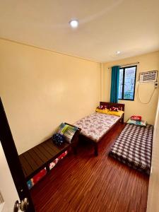 DapitanAffordable Fully Furnished House with 3 Bedroom for Family and Big Groups的客房设有床、桌子和窗户。