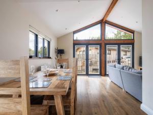 a dining room with a wooden table and a large window at Lodge W Hot Tub, Outdoor Dining In National Park in Otterburn