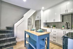 a kitchen with a blue island with wine glasses on it at Sherby LUX - Central, Parking, Renovated, Sleeps 6 in Sherbrooke +14 photos