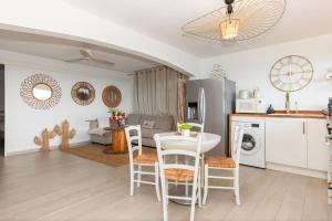 a kitchen and living room with a table and chairs at Mont Choisy Vue imprenable sur la mer et spa 2BDcanapé in Happy Bay