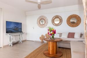 a living room with a couch and a table with flowers at Mont Choisy Vue imprenable sur la mer et spa 2BDcanapé in Happy Bay