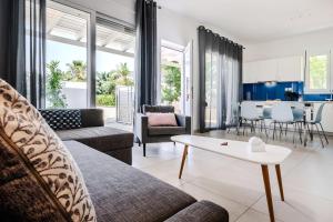 a living room with a couch and a table at Sea view - Villa Emmanouella in Makry Gialos