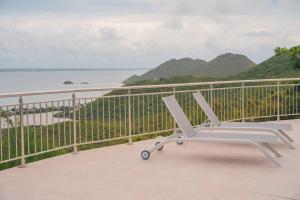 Friar's BayVilla Sunset Heights - La Savane的白色椅子,位于俯瞰水面的阳台