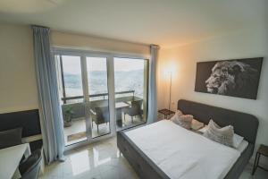 a bedroom with a bed and a large window at Tessa&Aurora - Incredible Lake View & Pool with Parking in Lugano +23 photos