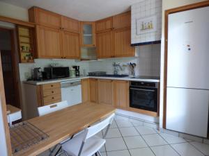 a kitchen with wooden cabinets and a white refrigerator at Villa les muriers in Manosque