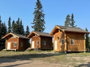 a group of cottages in front of some trees at Red Cariboo Resort in Anahim Lake
