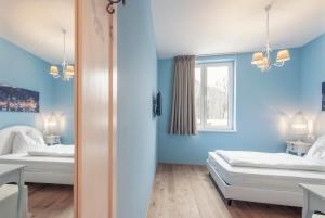 a blue room with two beds and a window at La Cucina - Hotel & Restaurant in Peggau +14 photos