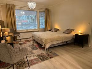 拉彭兰塔Two-room apartment的一间带床、窗户和椅子的卧室