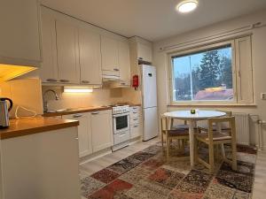 a kitchen with a table and a white refrigerator at Two-room apartment in Lappeenranta