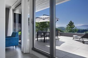 a room with a large glass window with a table with an umbrella at FeelFree STAYS Basoa in Donostia-San Sebastián