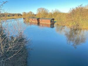 Un río con dos barcos en el agua en Thurne River Lodge Houseboat, en Stalham