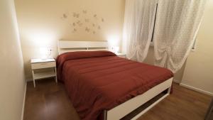 a bedroom with a bed with a red comforter and a window at Le Lune di Diana in Matera