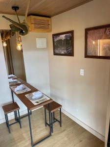 a room with a table with two chairs and a wall at Chalé Contêiner com Vista para Serra da Canastra in São Roque de Minas