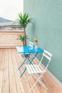 a blue table with two chairs and a palm tree at La Cucina - Hotel & Restaurant in Peggau