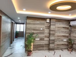 a lobby with a wooden wall with plants at Hotel Shyama Palace in Jamshedpur +53 photos