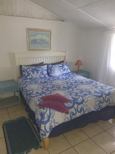 a bedroom with a bed with a blue and white comforter at Chalet 4 at Cynthias Country in Hartbeespoort