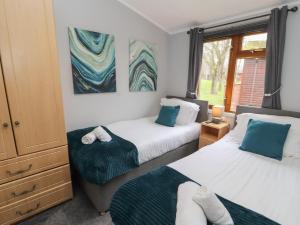 a bedroom with two beds and a window at Lakeside 18 in Carnforth