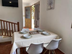 a dining room table with a white table cloth and chairs at Castaño II in Valle Gran Rey +14 photos