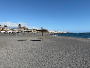 due ombrelloni su una spiaggia con l'oceano di Salitreja a Puertito de Güímar