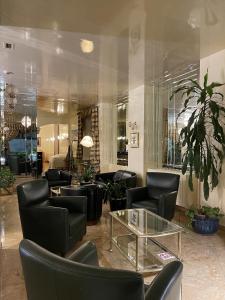 a lobby with black chairs and a glass table at Hotel Europa Fiera in Rho