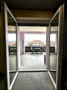 an open glass door to a patio with a table at La Terrazza in Cantarana +14 photos